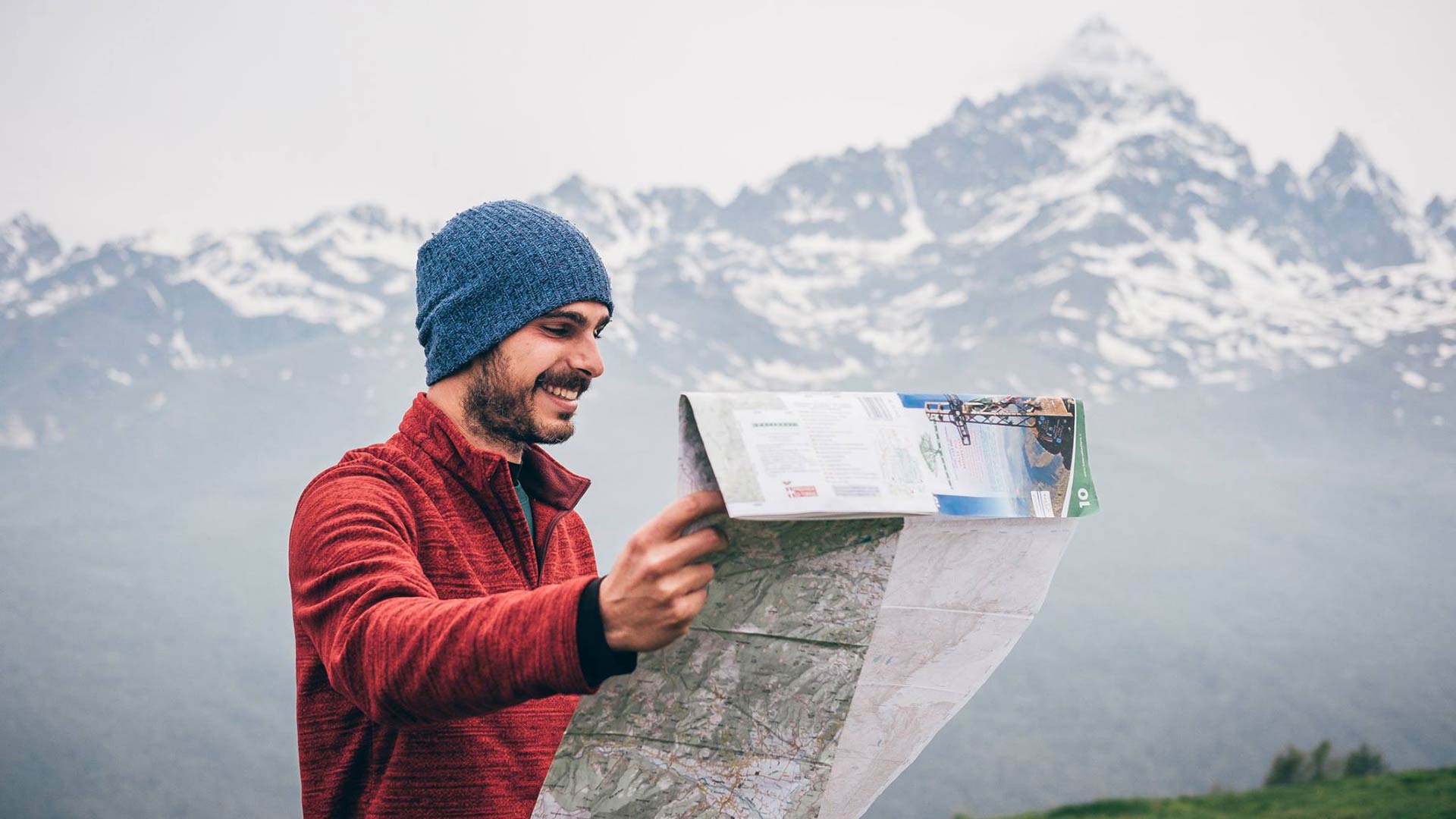 Guida escursionistica che legge la cartina davanti al Monviso Guida escursionistica che legge la cartina davanti al Monviso