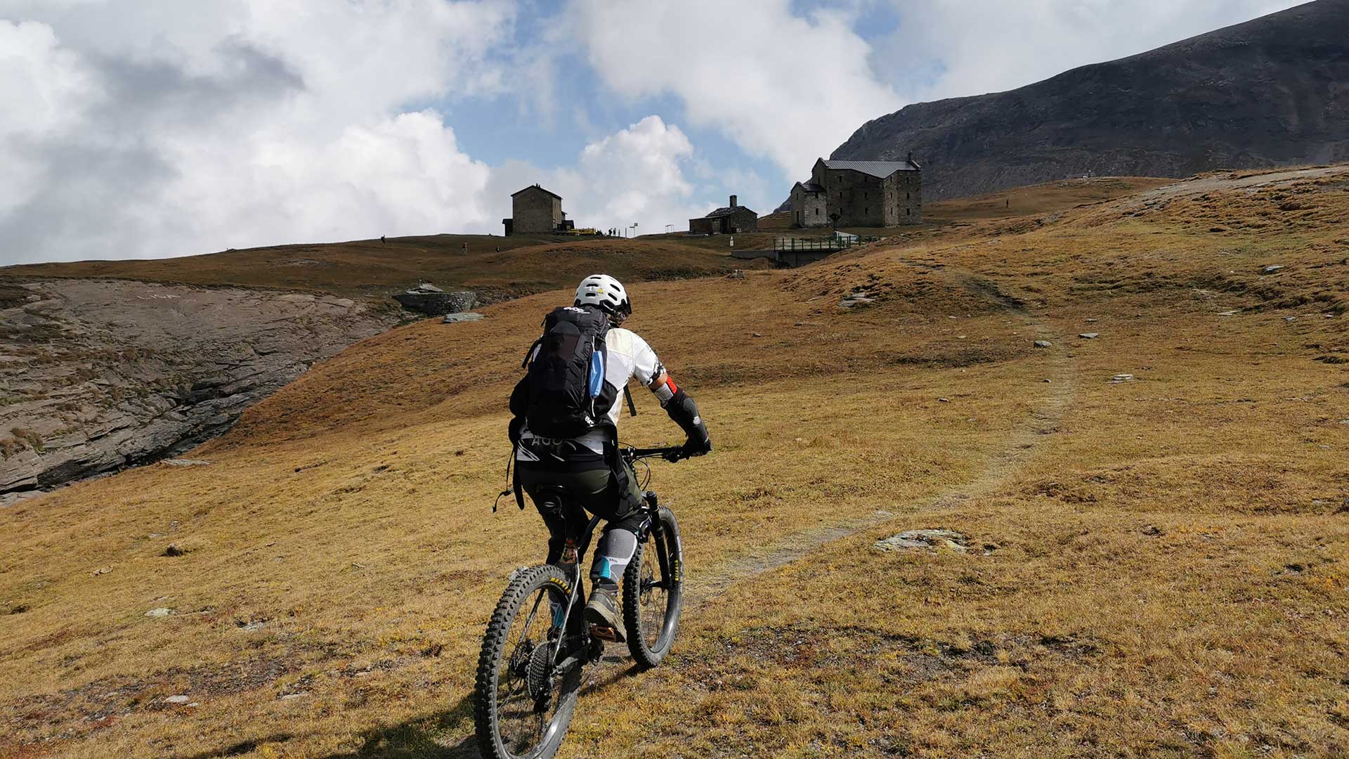 Biker in mountain bike su un sentiero d'alta quota nel Parco Nazionale del Gran Paradiso Biker in mountain bike su un sentiero d'alta quota nel Parco Nazionale del Gran Paradiso